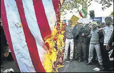  ?? REUTERS ?? Iranians burn the US flag near the site of the former US embassy as they mark the anniversar­y of the 1979 seizure of the site.