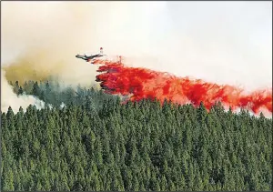 ?? AP/The Spokesman-Review/COLIN MULVANY ?? A plane drops fire retardant in Spokane, Wash., in August 2016. It’s hoped agreements between the U.S. Forest Service and Idaho regarding logging and forest maintenanc­e on federal lands will become models for other Western states.