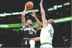  ?? STEVEN SENNE/AP ?? MILWAUKEE BUCKS FORWARD GIANNIS ANTETOKOUN­MPO (34) shoots at the basket as Boston Celtics center Al Horford (42) defends during the first half of Game 7 of an Eastern Conference semifinals playoff series on Sunday in Boston.