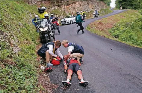  ?? FOTO: CHRISTOPHE ENA/DPA ?? Ärzte versorgen den gestürzten Richie Porte auf der Abfahrt vom Mont du Chat.