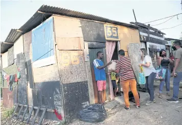  ?? REUTERS ?? Residents of Cidade de Deusslum receive food donations amid a Covid-19 outbreak, in Rio de Janeiro.