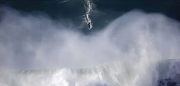  ??  ?? A surfer rides a big wave during a tow-in surfing session at the Praia do Norte or North beach in Nazare, Portugal yesterday. The beach has become a famous spot for big wave surfers around the world after Hawaiian surfer Garrett McNamara set a world...