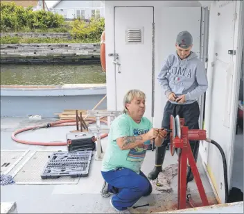  ?? SHARON MONTGOMERY-DUPE/CAPE BRETON POST ?? Fishermen Dennis Truckair of Glace Bay, left, and his son Nick, 17, who fish aboard the Rollin Stone, work at changing the lobster hauler to a long liner at the Glace Bay harbour on Thursday, in preparatio­n for halibut fishing. Truckair, one of the many fishermen who doesn’t want to see Donkin Mine barge its coal, said there is a railbed that still goes out to Donkin and only a small piece would be needed to extend it to the mine.