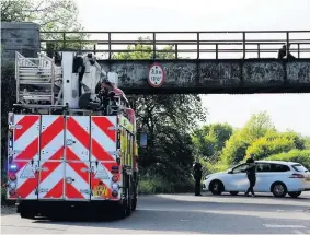  ??  ?? Action The road was sealed off as crews dealt with the deliberate blaze