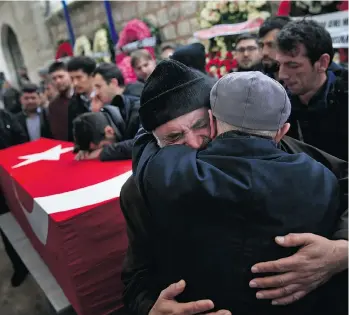  ?? LEFTERIS PITARAKIS/THE ASSOCIATED PRESS ?? Mustafa Alan, centre, the father of bombing victim Mehmet Alan, 29, embraces a mourner next to his son’s coffin during the funeral procession in Istanbul on Tuesday.