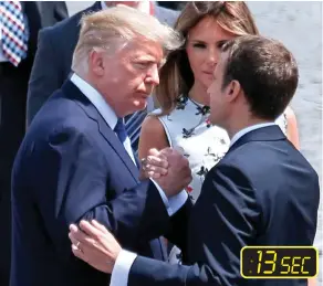  ??  ?? Still holding on: President Macron gestures with his free hand Change of grip: The pair now take up an arm-wrestling position