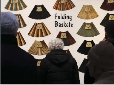  ?? (AP/Julia Nikhinson) ?? People shop for baskets made out of chopsticks in Bryant Park’s Winter Village in New York earlier this month.