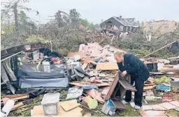  ?? JOHN RUSSELL/AP ?? Theresa Haske sorts through debris from what was her garage Friday after a rare tornado in Gaylord, Michigan. Two people died and more than 40 were injured.