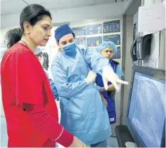  ?? MARK LENNIHAN/AP PHOTOS ?? Dr. Annapoorna Kini, centre, reviews a patient’s angiogram before beginning a procedure, as a colleague points to the screen at Mount Sinai Hospital in New York. There’s never been a better time to be treated for a heart attack. U.S. hospitals have set...