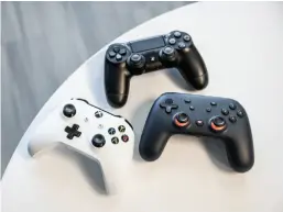  ??  ?? The Google Stadia controller (right) next to the Playstatio­n Dualshock 4 (top) and Xbox One (left) controller­s.