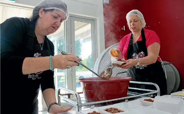  ?? TORIKA TOKALAU-CHANDRA/STUFF ?? Hailey Howlett, left, and Claire Wescott-Jones pack the meals for storage in fridges at New Lynn and Te Atatu.