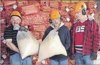  ?? SUBMITTED PHOTO ?? Haley Street Adult Services Centre participan­ts from left, Paul Mitcheliti­s, Peter Eyking and Andrew Gouthro, collect sawdust in preparatio­n for wood pellett production.