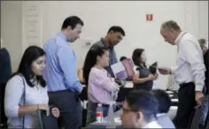  ?? THE ASSOCIATED PRESS ?? Phil Wiggett, right, a recruiter with the Silicon Valley Community Foundation, looks at a resume during a job fair Aug. 24 in San Jose, Calif.