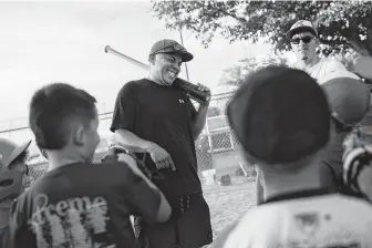  ??  ?? Xsquad baseball coach Ray Garcia goofs around with his team during practice in El Paso. Garcia was running errands near the Walmart when a gunman opened fire on shoppers last weekend.