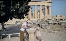  ?? Foto: Petros Giannakour­is/ap ?? Besökare tvättar händerna framför Parthenon vid Akropolis i Aten.