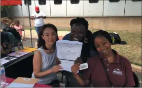  ?? L.A. PARKER - THE TRENTONIAN ?? (Left-to-right) Trenton Free Public Library librarian Jungwon Devone, Eboni Love, a library assistant, and Akira Harris, a library page, signed up more than 200 students and adults for library cards during the Trenton Board of Education “Back To School Extravagan­za.”