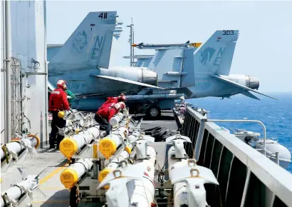  ?? — AP ?? US Navy crewmen from the US Navy aircraft carrier USS Carl Vinson (CVN 70) prepare to load missiles to F-18 fighter jets prior to a routine patrol off the disputed South China Sea on Friday.