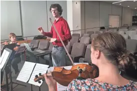  ?? KERRY LENGEL/THE REPUBLIC ?? Graduate-student composer Zachary Bush conducts a rehearsal for a new piece inspired by research into Alzheimer's disease as part of an Arizona State University Biodesign Institute project dubbed "Science Exposed."