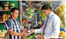  ?? ?? An LOLC Finance officer accepting cash from a customer and depositing it instantly through a POS machine