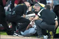  ?? ERIN HOOLEYCHIC­AGO TRIBUNE ?? A’s starter Chris Bassitt holds a bloody towel to his face as trainers and emergency medical technician­s attend to him.