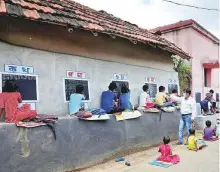  ?? Reuters ?? ■
Deep Narayan Nayak teaches children in an open-air class outside houses with the walls converted into blackboard­s.