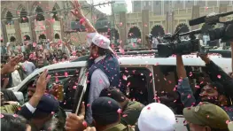  ?? — AFP ?? Jamat-ud-Dawa chief Hafiz Saeed waves to supporters as he leaves a court in Lahore on Thursday.