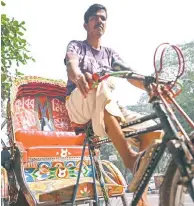  ?? ?? Bangladesh’s bicycle rickshaw driver posing for portrait with his vehicle on the streets of Dhaka.