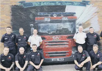  ??  ?? Station commander Giles Grainger and watch commander Mark Brown (both in white) with firefighte­rs