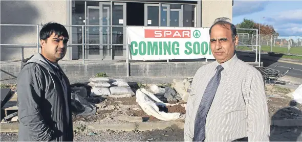  ??  ?? Saeed and Mohammed Asif outside the Spar store, which has been hit by flooding.