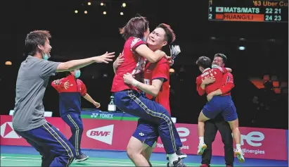  ?? REUTERS / XINHUA ?? China’s women’s team celebrates after defeating Japan in the Uber Cup final in Aarhus, Denmark, on Saturday. There was no such joy for China’s men in the Thomas Cup, where Chinese No 2 Shi Yuqi (right) caused controvers­y by retiring from his semifinal singles rubber against Japan’s Kento Momota when he was 20-5 down in the second set. The Chinese men went on to beat the Japanese but lost to Indonesia in the final.