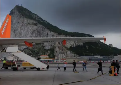 ?? (Phil Noble/Reuters) ?? PASSENGERS DISEMBARK from an easyJet flight after arriving at Gibraltar Airport in April. EasyJet said its support for electric planes was part of a broader strategy to reduce carbon and nitrous-oxide emissions in the aviation sector.