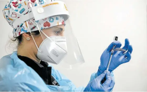  ??  ?? Una enfermera prepara una vacuna contra la covid-19 de Pfizer.