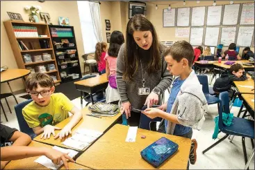  ?? NWA Democrat-Gazette/ANTHONY REYES •@NWATONYR ?? Audrey King, fourth-grade teacher at Tucker Elementary School, helps Michael Girenko, 9, with his assignment Tuesday at the Rogers district school in Lowell. Enrollment in Rogers elementary schools has grown by 334 students since the start of the...