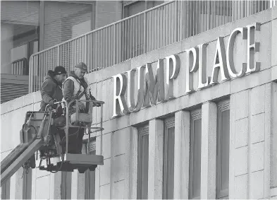  ?? SETH WENIG / THE ASSOCIATED PRESS ?? Workmen remove the letters from a building formerly known as Trump Place in New York City after hundreds of residents signed a petition saying they were embarrasse­d to live in a place associated with the president-elect.