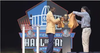  ?? AARON DOSTER/USA TODAY SPORTS ?? Class of 2018 member Randy Moss stands with son Thaddeus Moss as his bust is unveiled during the Pro Football Hall of Fame enshrineme­nt ceremony.