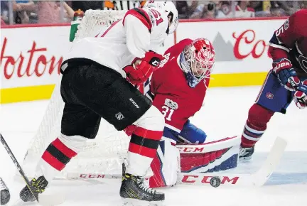  ?? ALLEN MCINNIS ?? Habs goalie Carey Price gets his stick on the puck as the Devils’ Brandon Gignac looks for a rebound Thursday night at the Bell Centre.