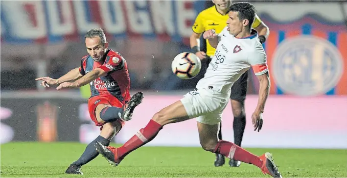  ?? AFP ?? Remate. Prueba Belluschi ante el cierre del capitán Cáceres. Aceptable partido del volante, que llevó la 10. Los paraguayos jugaron 26 minutos con uno menos por la roja a Espínola.