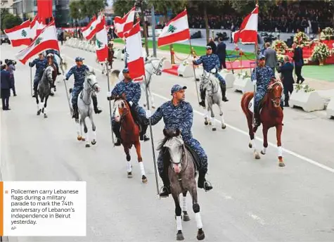  ?? AP ?? Policemen carry Lebanese flags during a military parade to mark the 74th anniversar­y of Lebanon’s independen­ce in Beirut yesterday.