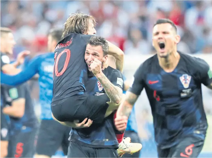  ?? FrANk AugsteiN / AFp ?? Se abrazan Luka Modrić y Mario Mandžukić, autor del gol de la victoria por 2-1 sobre Inglaterra; se desahoga Dejan Lovren