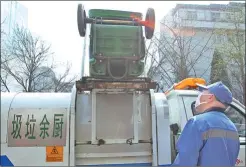  ??  ?? Special garbage trucks labeled for “kitchen waste” are used to transport and dump refuse in Beijing.