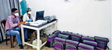  ?? Reuters ?? ↑
Laboratory technician­s sit next to boxes containing COVID-19 testing kits at a sample collection centre in Ahmedabad on Thursday.