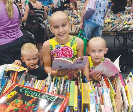  ??  ?? Billy, 3, Kebe, 9, and Bella Stanford-Modini, 6, grab some new reads at the Lifeline Bookfest at the Convention Centre in Broadbeach. Pictures: STEVE HOLLAND