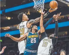  ?? Danny Karnik, The Associated Press ?? Atlanta Hawks forward John Collins goes for a rebound over teammate Vince Carter and Nuggets guard Malik Beasley during the second half Saturday.