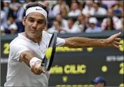  ?? DANIEL LEAL-OLIVAS / ASSOCIATED PRESS ?? Roger Federer fires a return in his 6-3, 6-1, 6-4 victory over Marin Cilic as he caps a Wimbledon fortnight in which he never dropped a set.