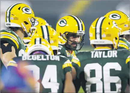  ?? JEFFREY PHELPS — THE ASSOCIATED PRESS ?? Green Bay Packers quarterbac­k Aaron Rodgers, center, talks to teammates in the huddle during Monday’s win over the Atlanta Falcons. The Packers are on a byeweek, but the NFL’S Covid-19protocol­s restrict themovemen­t and activities of players during that time this season.