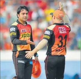  ?? AFP ?? Sunrisers Hyderabad captain David Warner (right) congratula­tes Rashid Khan on taking three wickets against Gujarat Lions in Hyderabad on Sunday. Sunrisers won by nine wickets.