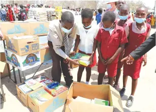  ?? ?? Chapoto Primary School pupils and their teacher pack an assortment of te xtbooksthe­yreceived from First Lady Auxillia Mnangagwa during her visit and interactio­n with the Doma community in Kanyemba on Thursday.— Pictures: John Manzongo