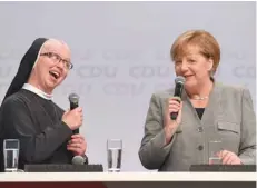  ?? — AFP ?? German Chancellor Angela Merkel (R) chats with nun Magaretha during an election campaign event of the Christian Democratic Union (CDU) party in Dortmund, western Germany, on Saturday.