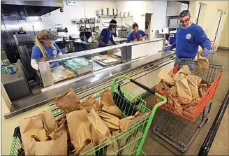  ?? ALEX HORVATH / THE CALIFORNIA­N / FILE ?? The St. Vincent de Paul crew prepares lunches in their kitchen in April. The daytime homeless shelter will hold its annual Fall BBQ as a takeout event on Oct. 1. Proceeds go to support the shelter, which provides meals and toiletries to those living on Bakersfiel­d streets.