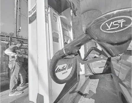  ?? DAMIAN DOVARGANES/ AP ?? A motorist pumps gasoline at United Oil gas station in Los Angeles on Friday. While the national average price of gas was $ 3.95 on Tuesday, it was a national- high of $ 5.36 in California. AAA data shows gas prices have been slipping daily since their mid- June peak, with most days knocking between 1 and 3 cents off the national average.